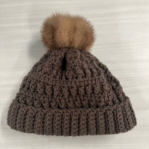 Knit hat / beanie w/ a natural mink fur pom-pom. Folded brim, cable knit. Brown
